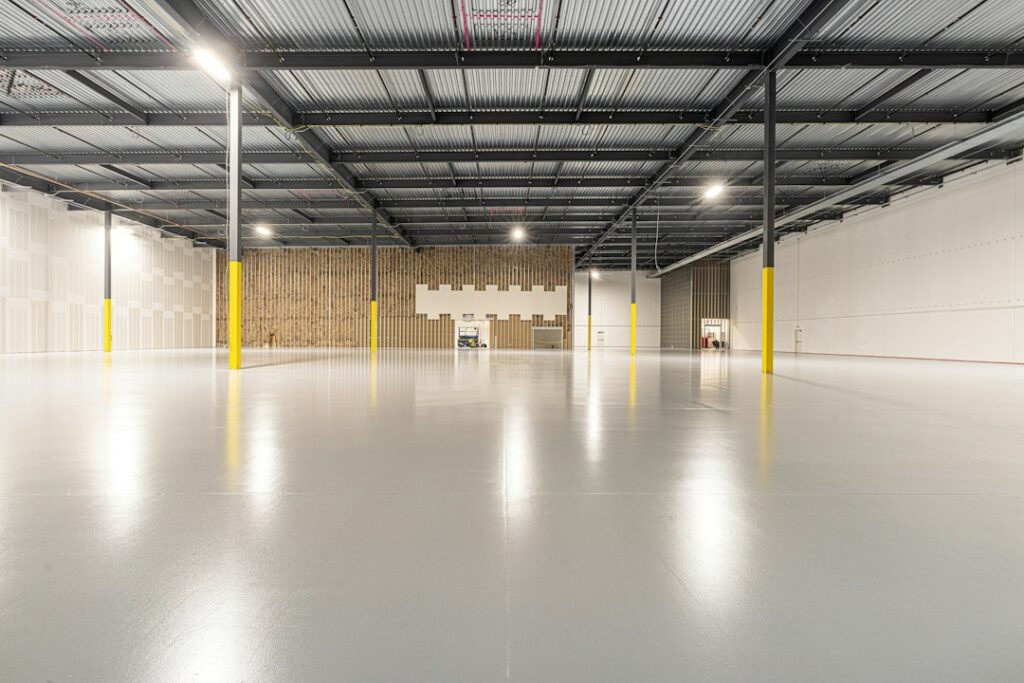 Business owners review a floor plan and lease documents at a table inside an unfinished commercial space.